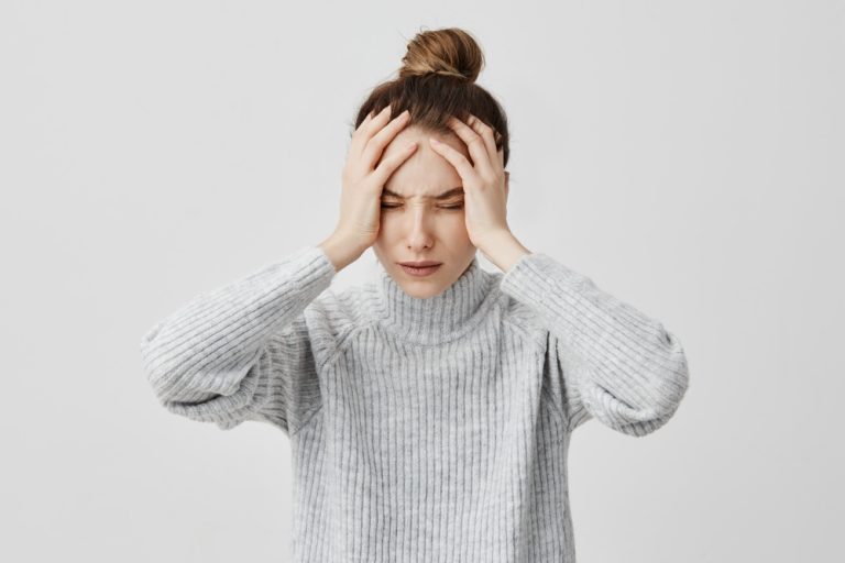 femme qui se tient la tête dans les mains