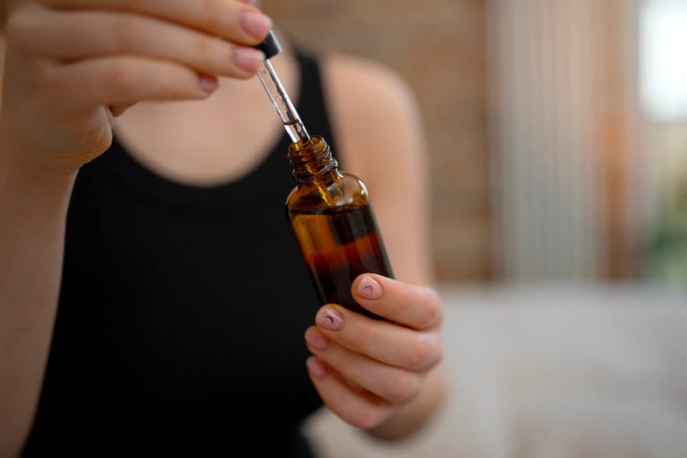 Femme utilisant une pipette d'huile